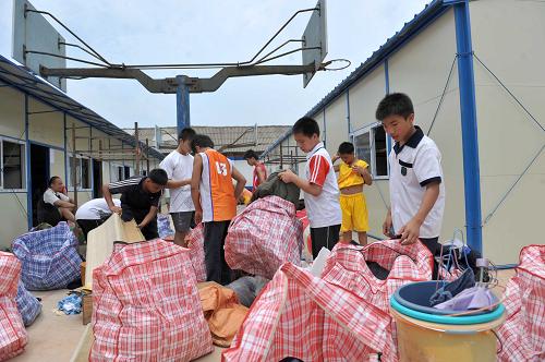 6月8日,在廣西來(lái)賓市實(shí)驗(yàn)中學(xué),學(xué)生們?cè)谡砦锲窚?zhǔn)備搬進(jìn)活動(dòng)板房。受弱冷空氣和西南暖濕氣流共同影響,6月8日至10日,廣西將有一次強(qiáng)降雨天氣過(guò)程。為防止學(xué)生再次受到降雨影響,6月8日,廣西來(lái)賓市實(shí)驗(yàn)中學(xué)首批240名學(xué)生緊急搬進(jìn)新建的活動(dòng)板房,其余120名學(xué)生,暫時(shí)被安排在該校拳擊館,等在建的12間活動(dòng)板房建成后,也將以最快的速度搬遷。6月1日,受持續(xù)暴雨影響,廣西來(lái)賓市實(shí)驗(yàn)中學(xué)600多名學(xué)生被洪水圍困。