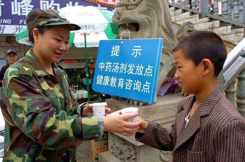 9月5日,在舟曲縣春江廣場發(fā)放點(diǎn),蘭州市第一人民醫(yī)院急診科護(hù)士長魯海燕(左)正在向當(dāng)?shù)匾幻麅和l(fā)放中藥湯劑。為預(yù)防災(zāi)后傳染病疫情的發(fā)生,減少災(zāi)區(qū)群眾患感冒、腹瀉等常見病的幾率,由甘肅省衛(wèi)生廳統(tǒng)一配制、熬成的中藥湯劑自8月27日起增加發(fā)放點(diǎn),開始在舟曲縣城11個固定發(fā)放點(diǎn)向?yàn)?zāi)區(qū)群眾免費(fèi)發(fā)放,受到當(dāng)?shù)厝罕姷臍g迎。目前,舟曲災(zāi)區(qū)沒有重大傳染病疫情發(fā)生,災(zāi)后舟曲從外地調(diào)運(yùn)的大批大蒜、花椒、黃花菜等食療中藥在衛(wèi)生防疫中起到了重要作用。