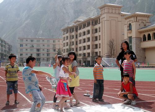 8月24日,孩子們在新建成的汶川第一小學(xué)田徑場上開心地玩耍。 新華社記者 肖思思 攝