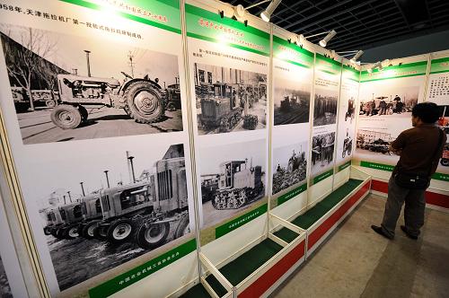 8月27日,一位觀眾在參觀中國(guó)農(nóng)機(jī)工業(yè)60年大型圖片展。新華社記者 孫參 攝