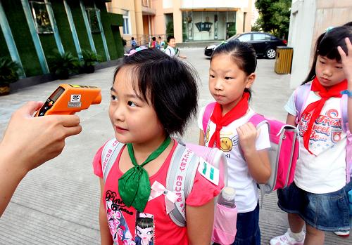 9月15日,上海市梅隴中心小學(xué)的學(xué)生在校門口接受體溫測量。由于季節(jié)性流感高峰期的到來,甲型H1N1流感防控工作面臨嚴峻形勢,因此上海市有關(guān)方面規(guī)定:從本周開始,上海市中小學(xué)、幼兒園要做到100%晨檢。每名學(xué)生早晨到校后都必須測量體溫才能進校。同時,部分學(xué)校、幼兒園要求家長止步于校門口,不能進入學(xué)校。 新華社記者 劉穎 攝