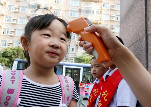 9月15日,上海市梅隴中心小學(xué)的學(xué)生在校門口接受體溫測量。 新華社記者 劉穎 攝