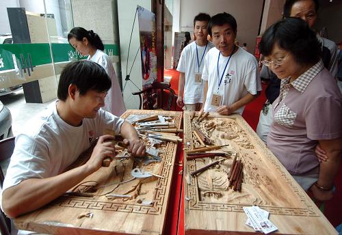 9月17日,一名民間藝人在博覽會現(xiàn)場展示木刻技藝。當(dāng)日,首屆中國(浙江)非物質(zhì)文化遺產(chǎn)博覽會·第六屆中國中華老字號精品博覽會在杭州開幕,共有來自13個?。ㄊ校┑慕?00個國家級和省級非物質(zhì)文化遺產(chǎn)項目、中華老字號品牌參展。 新華社發(fā)