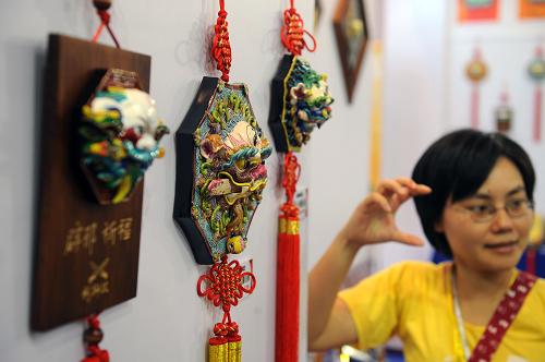 10月29日,臺(tái)灣客商在向觀眾介紹臺(tái)南安平劍獅埕展品。新華社記者 姜克紅 攝