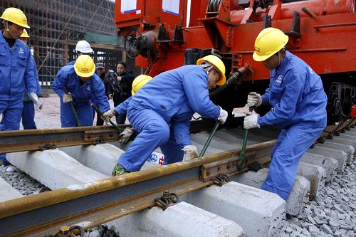 11月18日,鐵路建設(shè)者在漢宜高速鐵路宜昌段施工現(xiàn)場(chǎng)鋪軌。 新華社發(fā)(文振效 攝)