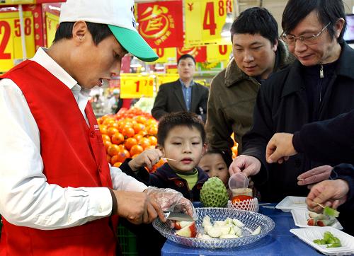 12月13日,上海市民在超市內(nèi)試吃蓮霧等臺(tái)灣水果。新華社記者 劉穎 攝