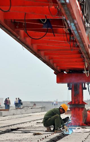 1月18日,工人在東環(huán)鐵路??陔p線特大橋橋面上施工。新華社記者 郭程 攝