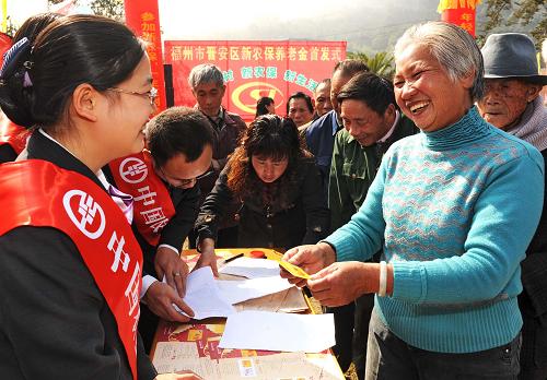 2月1日,福州市晉安區(qū)壽山鄉(xiāng)嶺頭村61歲的何銀花老人(右)高興地領(lǐng)到新型農(nóng)村社會養(yǎng)老保險銀行卡。 福建將于2010年在全省10%的縣(市、區(qū))啟動新型農(nóng)村社會養(yǎng)老保險試點。試點實行個人繳費、集體補助、政府補貼相結(jié)合的籌資方式。個人按年繳費,繳費檔次設(shè)為一年100元到1200元共12個檔次,供參保農(nóng)村居民自主選擇。政府補貼分為兩個部分,其中福建目前基礎(chǔ)養(yǎng)老金水平定為55元,由中央、省、市、縣四級財政承擔(dān)。同時省、市、縣三級財政對農(nóng)村居民繳費給予每人每年不低于30元的繳費補貼。有條件的村集體可以對村民參保繳費予以適當(dāng)補助。新華社記者 張國俊 攝