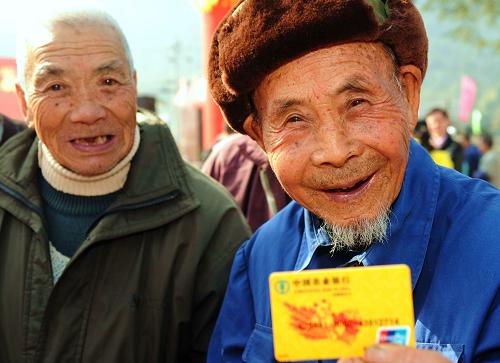 2月1日,福州市晉安區(qū)壽山鄉(xiāng)嶺頭村95歲的鄭純柱老人(右)高興地領(lǐng)到新型農(nóng)村社會養(yǎng)老保險銀行卡。新華社記者 張國俊 攝