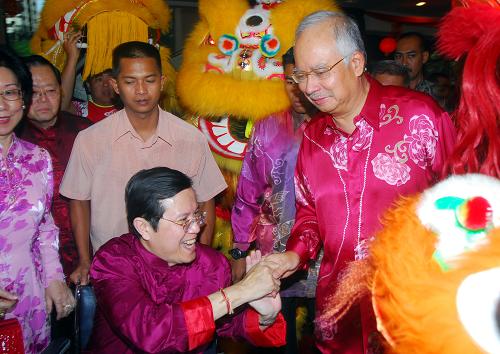 2月14日,在馬來(lái)西亞首都吉隆坡,馬來(lái)西亞總理納吉布(前右)在馬來(lái)西亞主要華人政黨馬來(lái)西亞華人公會(huì)總部參加新年慶?;顒?dòng)時(shí)與總會(huì)長(zhǎng)翁詩(shī)杰握手。新華社記者 熊平 攝