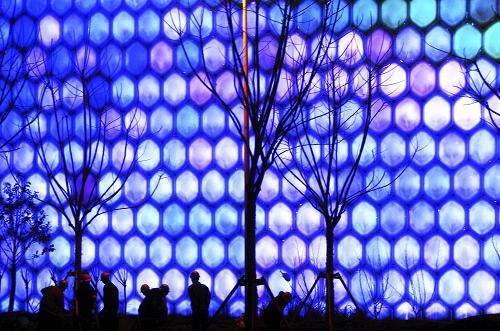3月11日,工人在進(jìn)行夜景燈光調(diào)試的信息通信館前施工。 新華社發(fā)