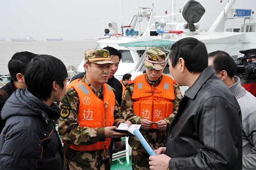 3月18日,執(zhí)法人員對船上工作人員相關(guān)證件進行比對。新華社發(fā)(邢守秒 攝)