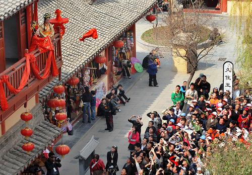 4月5日,游客在開封清明上河園內(nèi)觀看“清明上河圖”中“王員外招親”的表演。新華社記者 王頌 攝