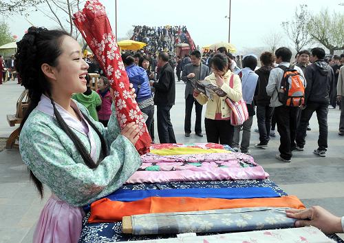 4月5日,在開封清明上河園內(nèi),一位“攤販”在叫賣絲綢布匹。新華社記者 王頌 攝