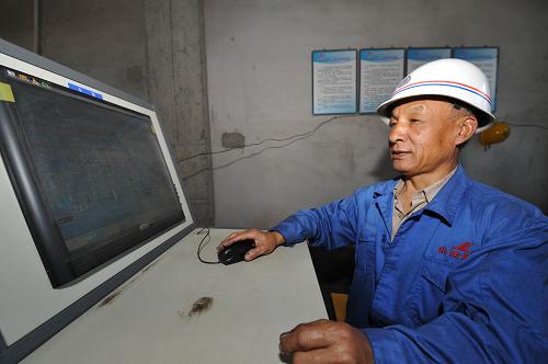 一位員工在阜康重化工業(yè)園區(qū)的一家焦炭廠內(nèi)通過計算機控制除煙除塵設備(6月9日攝)。新華社記者 趙戈 攝
