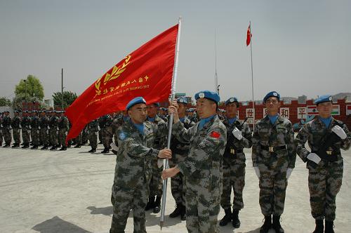 6月22日,在黎巴嫩南部哈尼亞舉行的中國維和工兵營權力交接儀式上,第六批中國工兵營營長王良斌(左)將象征中國工兵營權力的旗幟交到了第七批中國工兵營營長唐尚平手中。新華社記者 潘立文 攝