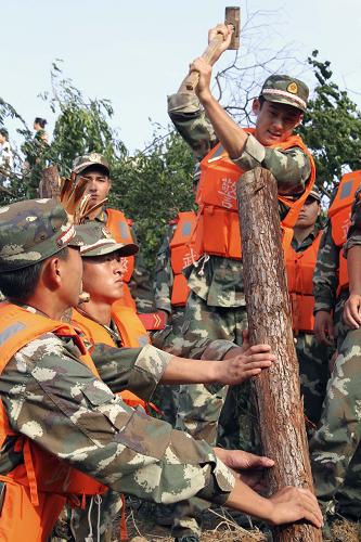 6月25日,武警官兵正在奮力打樁固壩。新華社發(fā)(戴慶明 攝)