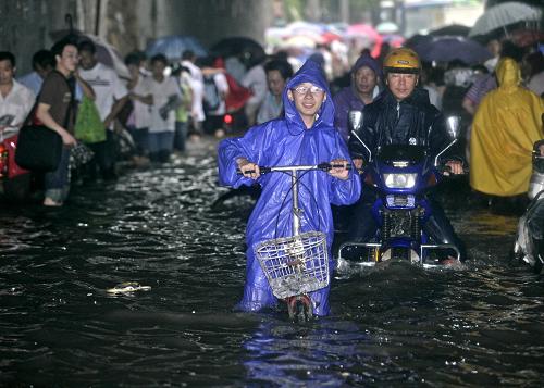 7月13日,武漢遭遇暴雨,市民涉水通過積水嚴重的路段。7月3日以來的暴雨災害已造成湖北90個縣市區(qū)不同程度受災,受災人口786萬人,因災死亡25人、失蹤2人。目前,強降水天氣仍在持續(xù),13日主要集中在武漢及其周邊地區(qū),預計從15日開始,雨勢將可能有所減弱,雨帶將向北抬。新華社發(fā)(王翮 攝)