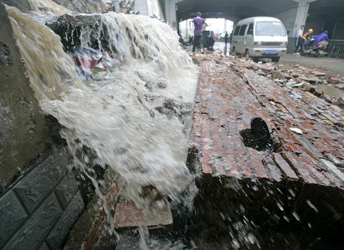 7月13日,武漢遭遇暴雨,大水將一面墻沖垮。新華社發(fā)(王翮 攝)