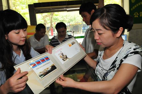 9月3日,在四川省南充市郵政營業(yè)大廳,集郵愛好者(右)向工作人員咨詢《中國人民抗日戰(zhàn)爭勝利65周年》郵折。9月3日是中國人民抗日戰(zhàn)爭勝利65周年紀(jì)念日,中國集郵總公司當(dāng)日發(fā)行《中國人民抗日戰(zhàn)爭勝利65周年》特種紀(jì)念封一枚,編號為PFTN-65。新華社發(fā)(李向雨 攝)