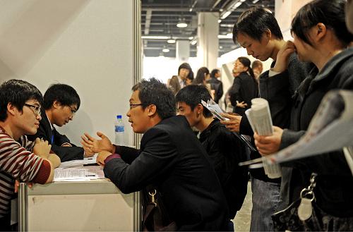 11月6日,求職者們在一家企業(yè)的招聘臺前排隊(duì)?wèi)?yīng)聘。新華社記者 譚進(jìn) 攝