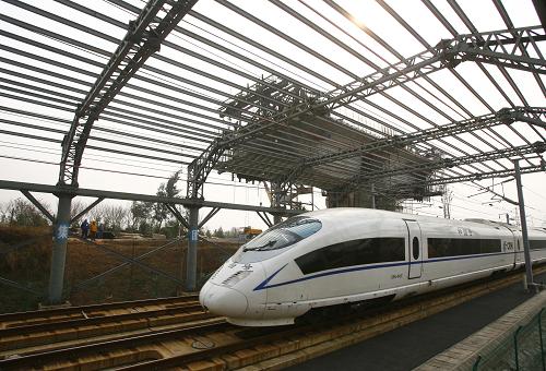 12月6日,武廣高鐵的一輛列車(chē)從武(漢)咸(寧)城際鐵路施工現(xiàn)場(chǎng)旁側(cè)駛過(guò)。新華社發(fā)(宋建春 攝)