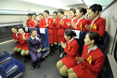 12月6日,在滬杭高鐵列車上,京津城際動車組乘務(wù)員與滬杭高鐵列車長(前左三)交流服務(wù)經(jīng)驗。新華社發(fā)(趙偉 攝)