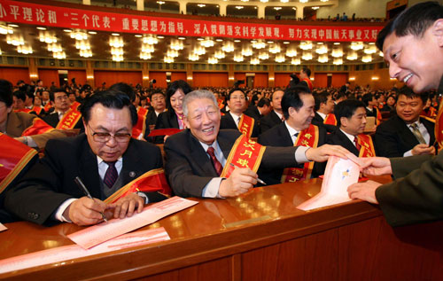 12月12日,慶祝中國首次月球探測工程圓滿成功大會在北京人民大會堂舉行。這是孫家棟(左二)等在會前為來賓簽名。 新華社記者 龐興雷 攝