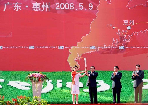 5月9日,惠州市市委書記黃業(yè)斌(左二)將火炬交給惠州市第一棒火炬手陳秀君(左一)。當(dāng)日,北京奧運(yùn)圣火傳遞活動(dòng)在廣東省惠州市舉行。 新華社記者劉力航攝