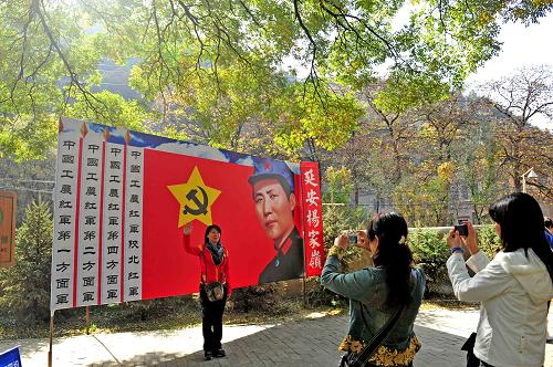 游客在延安楊家?guī)X革命紀(jì)念地的毛澤東巨幅畫像前留影(攝于10月18日)。新華社記者杜華舉攝