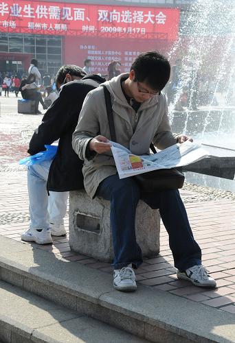 1月17日,兩位前來應(yīng)聘的學(xué)生坐在招聘會(huì)場(chǎng)外的石凳上瀏覽招聘信息。新華社記者 來建強(qiáng) 攝