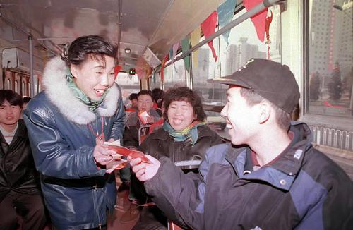 這是“乘客的貼心人”李素麗,大年初一在21路公共汽車上向乘客送上賀年卡,祝大家春節(jié)快樂(資料照片)。新華社記者 宋連峰 攝