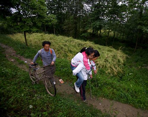 5月3日清晨,唐建華的父母護(hù)送女兒上學(xué)。“叔叔,給我買一瓶‘青蘋果’飲料好嗎?我好渴。”13歲的綿竹市漢旺鎮(zhèn)武都小學(xué)六年級學(xué)生唐建華左手捏著2塊錢,在廢墟中等待救援時對身旁的消防隊員說。 突如其來的災(zāi)難讓孩子們心中多彩的世界瞬間失去了色彩。再也看不到熟悉的校園,找不到老師與同學(xué),聽不到他們的歡聲笑語了。取而代之的只有滿眼灰色的殘垣斷壁。生與死的距離在那一刻被拉得如此之近。但是,生命的尊嚴(yán)永遠(yuǎn)高高屹立于廢墟之上??恐笊目释c活下去的信念,2008年5月13日上午11時,這個愛喝“青蘋果”飲料的女孩,在經(jīng)歷了長達(dá)20多個小時的埋壓后終于被成功救出。 “5·12”地震周年之際,記者驅(qū)車前往漢旺鎮(zhèn)學(xué)校的板房教室,找到了在地震中獲救的“青蘋果”女孩唐建華?,F(xiàn)在,唐建華已經(jīng)上初一了。在我們面前的她,紅撲撲的小臉、長長的辮子,安靜地坐著,身旁有一對拐杖。地震剛剛過去的那一段時間,小建華對余震特別敏感,夢里都會被驚醒。現(xiàn)在,這個學(xué)習(xí)努力又有點(diǎn)倔脾氣的孩子最關(guān)注的是怎樣才能不落下功課。由于被埋時間過長,唐建華的腰部骨折,足部跟腱萎縮,兩腳都出現(xiàn)不同程度的腳內(nèi)翻。在媽媽的強(qiáng)烈反對下,醫(yī)院當(dāng)
