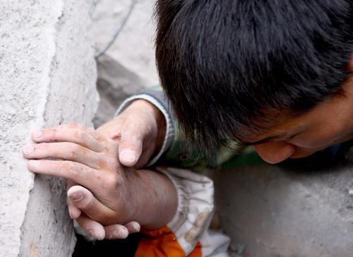 2008年5月13日,一位救援人員在四川綿竹市漢旺鎮(zhèn)武都小學(xué)對唐建華實施救援。新華社記者陳建力、趙宇思報道