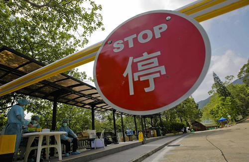 5月4日,香港民安隊(duì)隊(duì)員守候在用作隔離中心的麥理浩夫人度假村入口處。新華社記者 周磊 攝