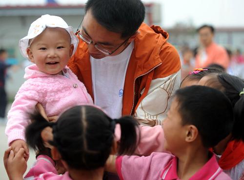 5月4日,李擁兵抱著孩子跟學(xué)生們玩耍。新華社記者 李曉果、秦晴報(bào)道