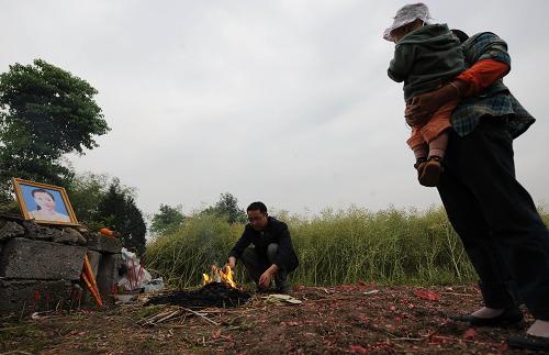 5月1日,李擁兵和家人給去世的妻子燒紙祭奠。新華社記者 李曉果、秦晴報(bào)道