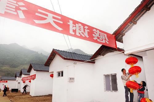 5月8日,受災(zāi)群眾在新居前懸掛燈籠。 當日,陜西省震后最大安置點——寧強縣燕子砭鎮(zhèn)東麗村集中安置點迎來原廟子嶺村首批50余戶受災(zāi)群眾喜遷新居。 位于陜、川、甘三省交界處的燕子砭鎮(zhèn)廟子嶺村,在“5·12”汶川地震中受災(zāi)嚴重。災(zāi)后,寧強縣決定將該村166戶近700名村民整體搬遷到燕子砭鎮(zhèn)木槽溝村,并為感謝天津市東麗區(qū)的對口援建將其更名為東麗村。這個陜西省最大的震后安置點,共建房166套、14000平米,總投資約3000萬元。其中天津投資近2000萬元援建水、電、路等基礎(chǔ)設(shè)施,目前整個工程已經(jīng)基本完工。 新華社記者陶明攝
