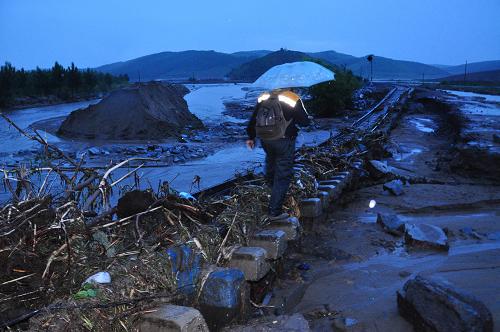 6月30日,剛剛修復(fù)通車的牡(丹江)密(山)鐵路北線再次遭遇洪澇災(zāi)害。當(dāng)日15時許,由于強(qiáng)降雨和山洪暴發(fā),黑龍江雞西新家站附近已經(jīng)修復(fù)的牡(丹江)密(山)鐵路北線兩處路基再次被洪水沖毀,五龍站附近一處路基被毀。洪災(zāi)造成兩列火車被困,交通全部中斷。目前鐵路部門正全力調(diào)集人力物力進(jìn)行搶修,并為旅客供應(yīng)食品。 新華社發(fā)(張春祥 攝)