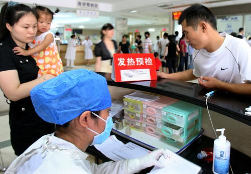 7月10日,患者在上海市閔行區(qū)中心醫(yī)院的發(fā)熱預(yù)檢臺(tái)前預(yù)檢。新華社記者 劉穎 攝