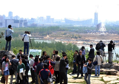 國家林業(yè)局17日宣布,經(jīng)過將近3年的建設(shè),奧林匹克森林公園綠化基本完成,奧運(yùn)苗木成活率超過99%。北京奧林匹克森林公園位于北京奧運(yùn)會主體育場館群北面,占地近7000平方米,公園種植喬灌木180多個(gè)品種,53萬多株,是北京最大的一塊人工綠地。圖為4月27日,記者們在北京奧林匹克森林公園主峰“仰山”上俯瞰鳥巢。新華社記者 羅曉光 攝