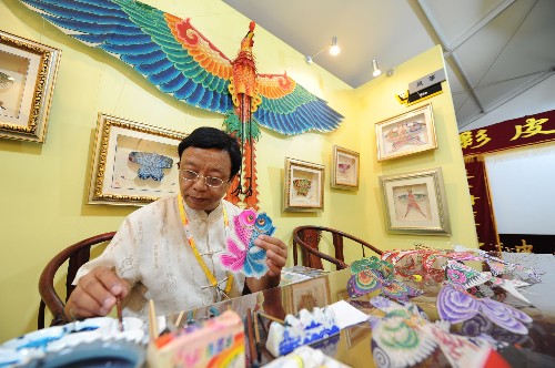 7月27日,在北京奧運村國際區(qū)商業(yè)街民俗文化區(qū),北京的民間藝術(shù)家哈亦琦在制作風(fēng)箏。新華社記者 趙鵬 攝