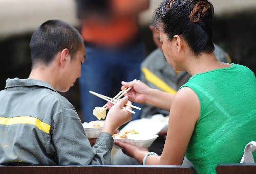 9月13日,一位母親(右)在午飯時(shí),給自己的孩子夾菜。中秋節(jié)前,云南省未成年犯管教所舉行“失足與關(guān)愛”中秋活動(dòng),昆明市中級(jí)人民法院的法官代表、“未管所”里部分學(xué)員以及他們的家屬相聚一起,提前度過一個(gè)充滿溫情的中秋節(jié)。新華社記者 鄒崢 攝
