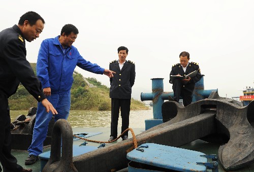 10月6日,秭歸縣地方海事處執(zhí)法人員在供油躉船上檢查錨鏈及錨索配備情況。新華社發(fā)(鄭家裕 攝)
