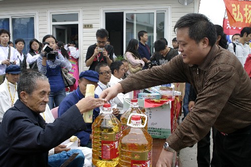 10月7日,工作人員在給地震災(zāi)區(qū)孤老發(fā)食用油等慰問品。新華社記者 葉建平 攝