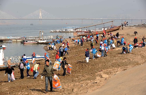 12月6日,參加清污活動的市民志愿者在湘江裸露的河床上拾垃圾。新華社記者 趙眾志 攝
