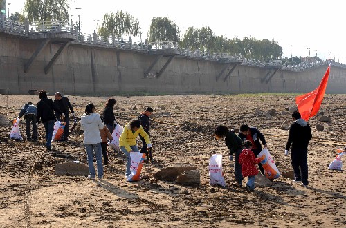 12月6日,參加清污活動的市民志愿者和學生在湘江岸邊拾垃圾。新華社記者 趙眾志 攝