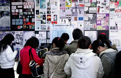 12月6日,大學(xué)生們在用自己創(chuàng)作的作品布置起來的供需洽談會現(xiàn)場與用人單位代表洽談。新華社發(fā)