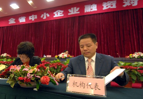 12月9日,一名機(jī)構(gòu)代表正在和企業(yè)代表簽署合作協(xié)議。新華社記者 黃深鋼 攝