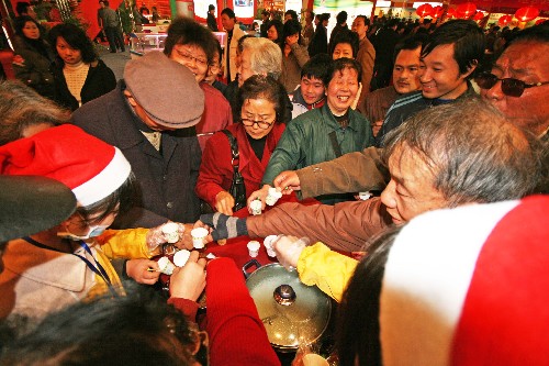 12月12日,在武漢舉行的食博會(huì)上,觀眾爭(zhēng)相品嘗特色小吃熱干面。新華社發(fā)(李理 攝)
